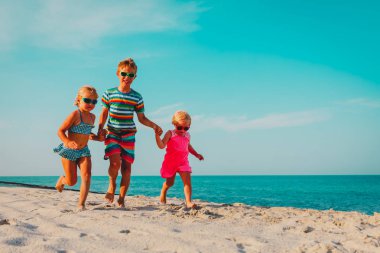 sahilde çalışan mutlu çocuklar, erkek ve kızlar denizde eğlenin
