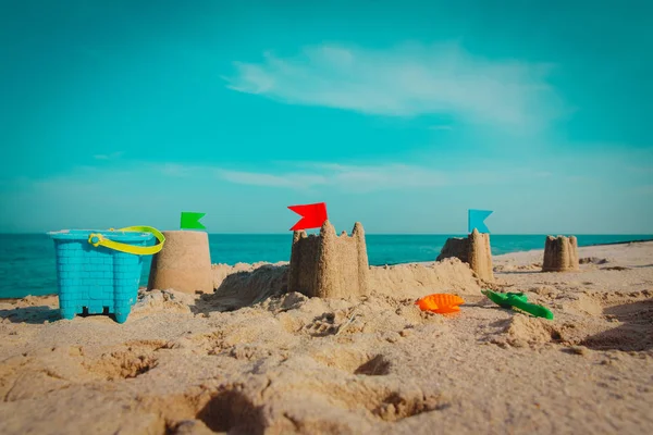 Castelo de areia em férias de praia e brinquedos — Fotografia de Stock