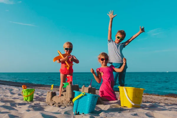 Crianças felizes - menino e meninas - brincar com areia na praia — Fotografia de Stock
