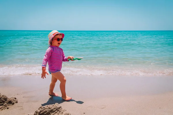 Ładna dziewczynka szczęśliwy grać z piasku na plaży — Zdjęcie stockowe