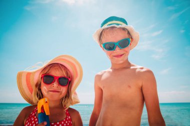 güneş koruma- plajda güneş kremi ile mutlu sevimli erkek ve kız