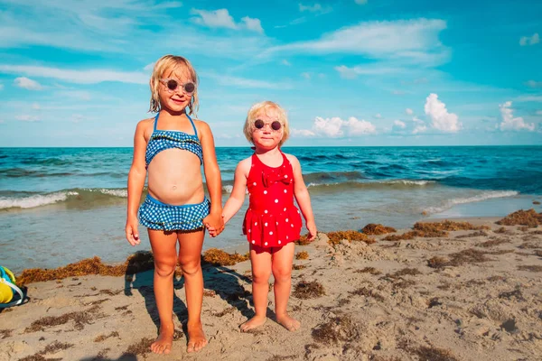 Mutlu sevimli küçük kızlar plajda su ile oynamak — Stok fotoğraf