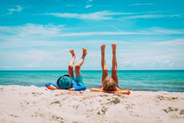 küçük erkek ve kız tropikal kumsalda sakin ol