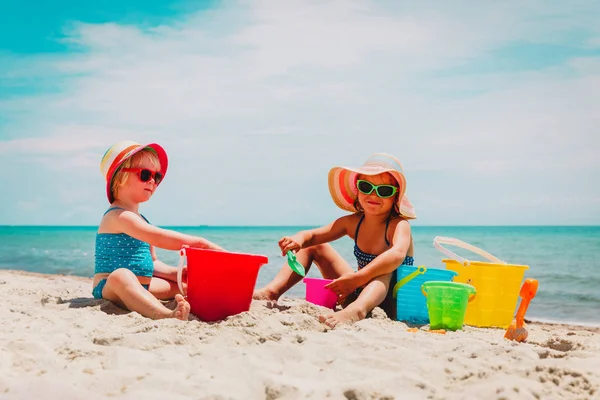 Meninas bonitos brincar com areia na praia de verão — Fotografia de Stock