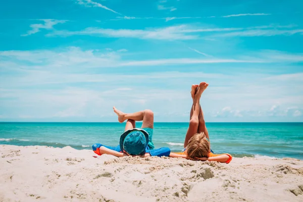 Bambino e ragazza rilassarsi sulla spiaggia tropicale — Foto Stock