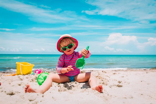 Sevimli mutlu kız kumsalda kumla oynuyor. — Stok fotoğraf