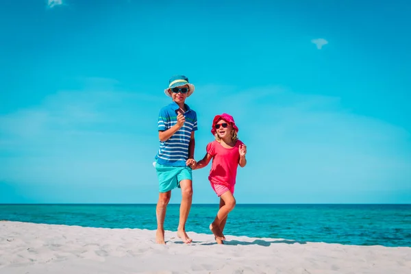 해변에서 달리는 행복한 귀여운 소년과 소녀 — 스톡 사진