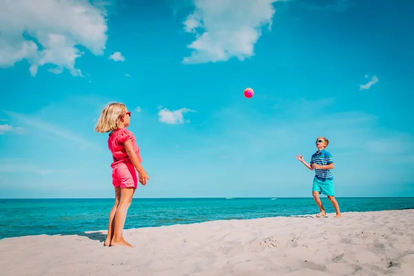 Kinderen spelen met bal op strand, jongen en meisje hebben plezier op zee — Stockfoto