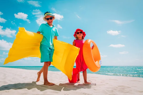 Aranyos boldog gyerekek, fiú és lány, menj úszni és játszani a strandon — Stock Fotó