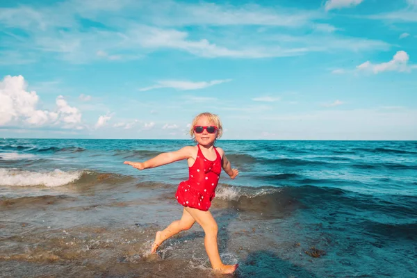 Feliz bonito menina jogar com ondas na praia — Fotografia de Stock