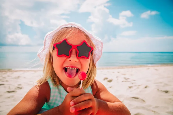 Милая счастливая маленькая девочка с леденцом на летних каникулах — стоковое фото
