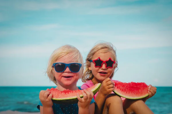 Sahilde karpuz yiyen mutlu sevimli küçük kızlar — Stok fotoğraf