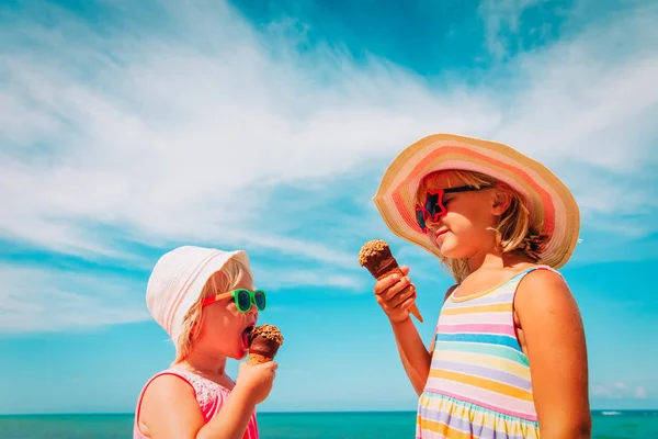 Feliz bonito meninas comendo sorvete na praia — Fotografia de Stock