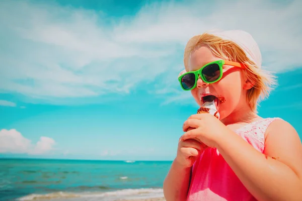 Feliz bonito menina comer sorvete na praia — Fotografia de Stock