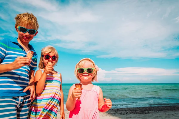 Rapazes felizes, rapazes e raparigas, a comer gelado na praia. — Fotografia de Stock