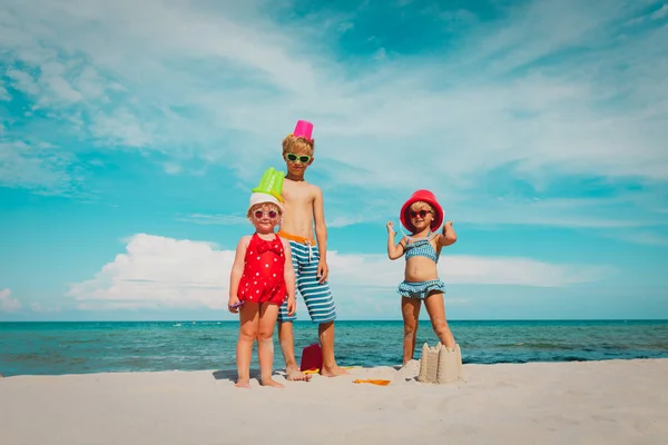 귀여운 아이 -소년과 소녀- 해변에서 장난감과 모래와 함께 놀이 — 스톡 사진