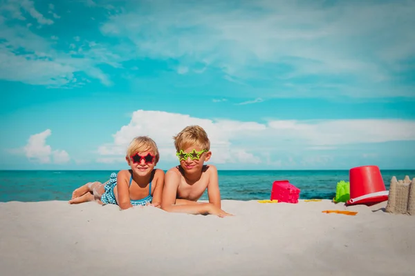 Bonito crianças menino e meninas brincar com brinquedos e areia na praia — Fotografia de Stock