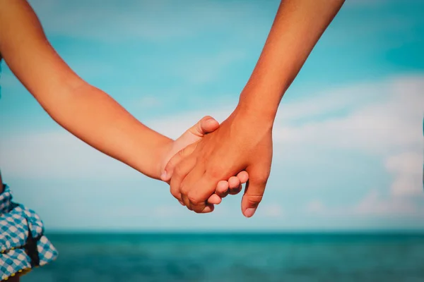 Мальчик и девочка, держащиеся за руки в море, дружба и забота — стоковое фото