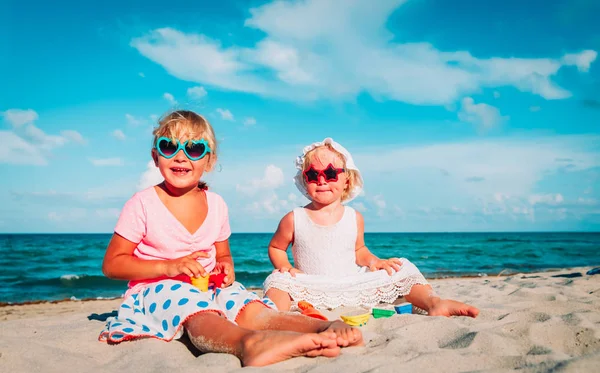 Niedliche Mädchen spielen mit Sand am Sommerstrand — Stockfoto