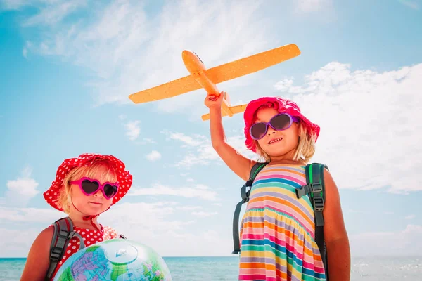 Kinder reisen am Strand, kleine Mädchen mit Globus und Spielzeugflugzeug auf See — Stockfoto