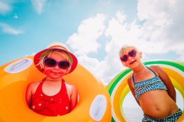 tropik plajda floaties ile mutlu sevimli küçük kızlar