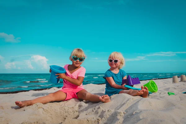 Crianças brincam com areia na praia de verão — Fotografia de Stock