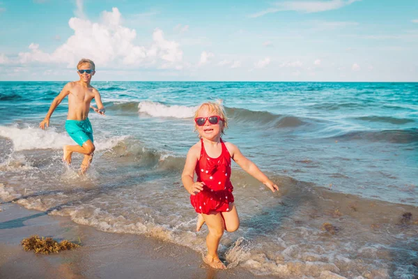 Ευτυχισμένο μικρό κορίτσι και το αγόρι τρέξιμο στην παραλία — Φωτογραφία Αρχείου