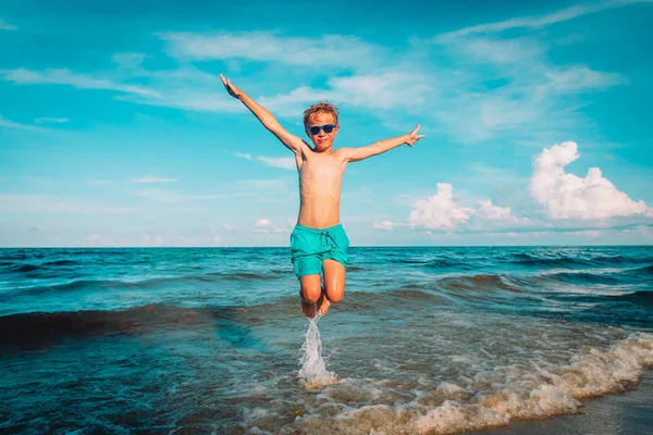 Счастливый маленький мальчик играет на пляже, ребенок наслаждается отдыхом — стоковое фото