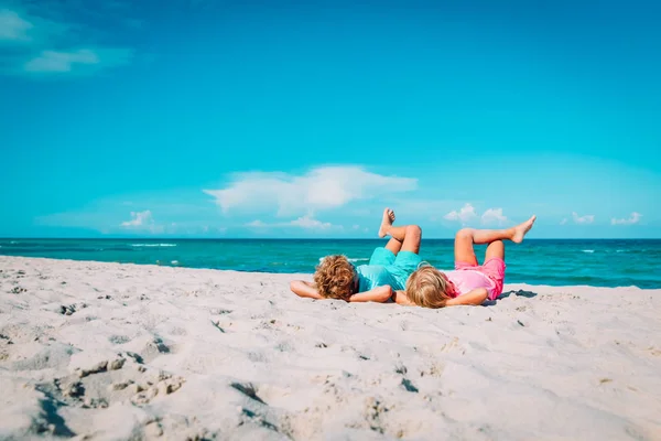 Gelukkig jongen en meisje ontspannen op tropisch strand — Stockfoto