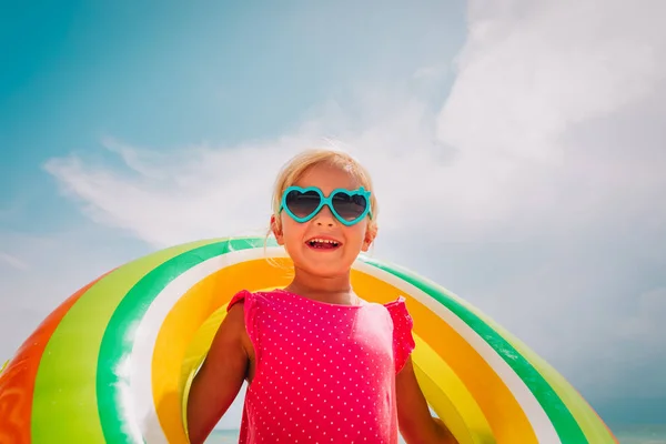 Plajda yüzen halka ile mutlu sevimli küçük kız — Stok fotoğraf