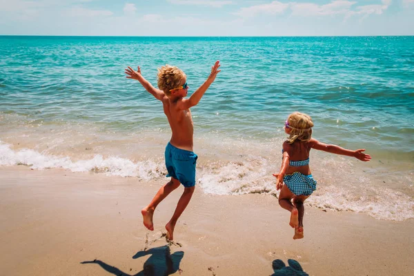 Felice ragazzo carino e ragazza giocare sulla spiaggia — Foto Stock