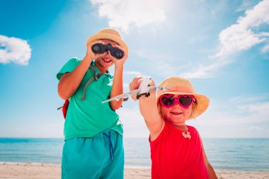 çocuklar plajda seyahat, oyuncak uçak ve dürbün ile erkek ve kız