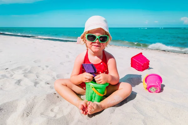 Bonito menina jogar com areia na praia — Fotografia de Stock