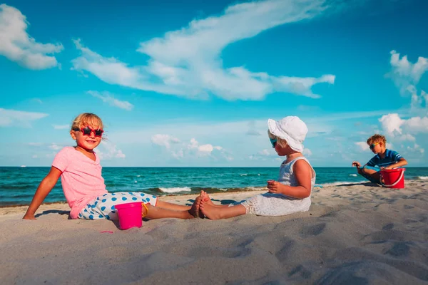 Rozkošné děti-dívky a chlapeček s pískem na pláži — Stock fotografie