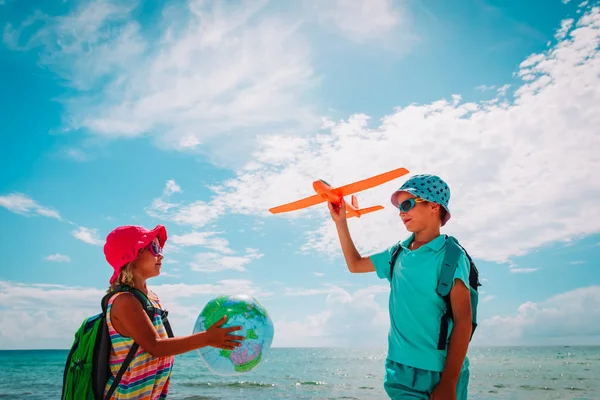 Niños viajan en la playa, niño y niña con globo y avión de juguete —  Fotos de Stock