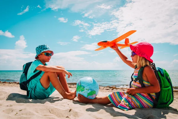 Niños viajan en la playa, niño y niña con globo y avión de juguete —  Fotos de Stock