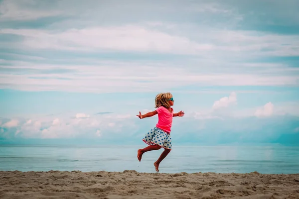 Милая счастливая девочка танцует, играет с детьми на летнем пляже — стоковое фото