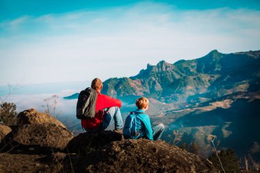 Baba oğul doğada seyahat eder, aile dağlarda yürüyüş yapar.
