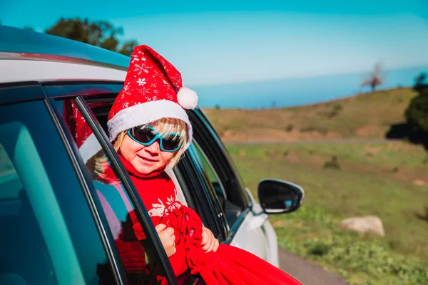 christmas car travel- happy little baby girl loves travel in winter