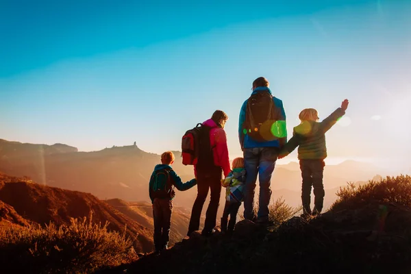 Счастливое семейное путешествие в горах на закате — стоковое фото