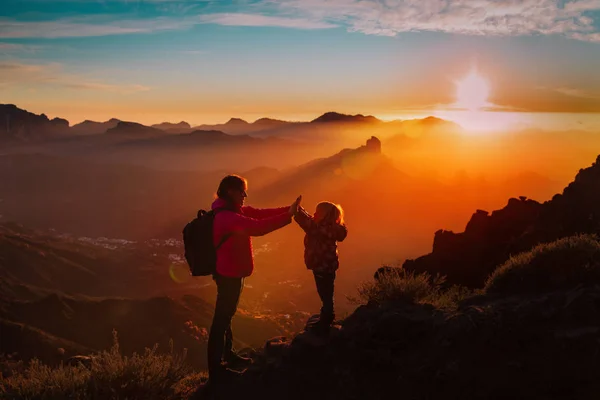 Мать с маленькой дочерью наслаждаться путешествием в горах заката — стоковое фото