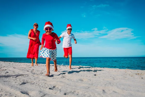 Família feliz mãe com filho e filho- comemorando o Natal na praia — Fotografia de Stock