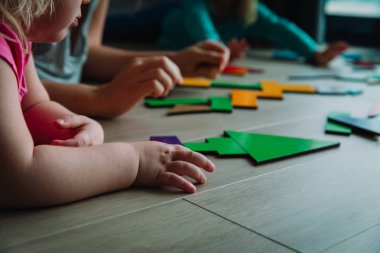 Öğretmen ve çocuklar bulmacayla oynar, tangram yaparlar.