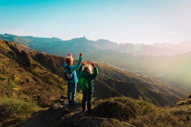 mutlu erkek ve kız günbatımında dağlarında seyahat, çocuklar yürüyüş zevk