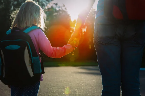 Pappa och lilla dotter går i skolan vid solnedgången — Stockfoto