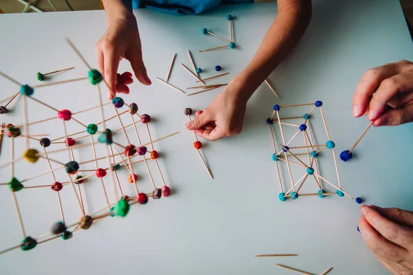 Maestro y niño haciendo formas geométricas a partir de palos y masa de juego — Foto de Stock