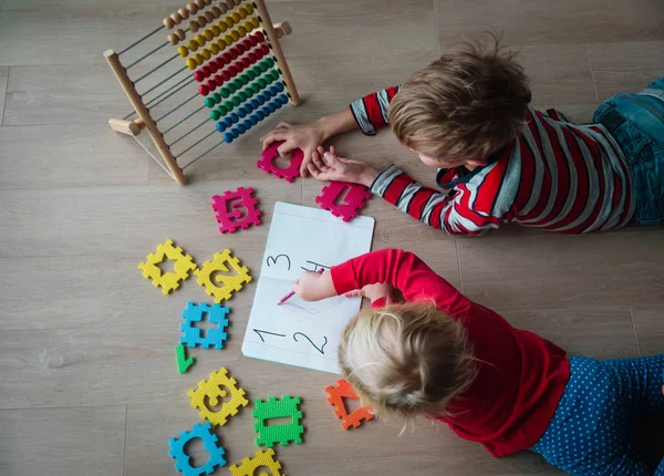 Garçon et fille apprendre à compter et écrire des nombres — Photo