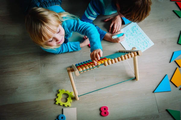 Kleine jongen en meisje leren om te schrijven en het berekenen van de getallen — Stockfoto