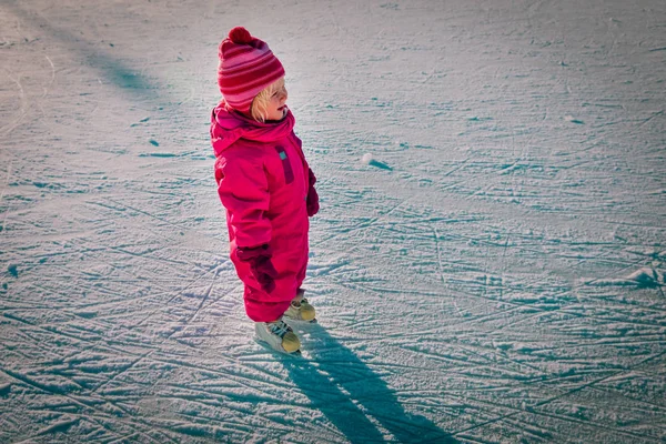 Счастливая маленькая девочка учится кататься зимой — стоковое фото