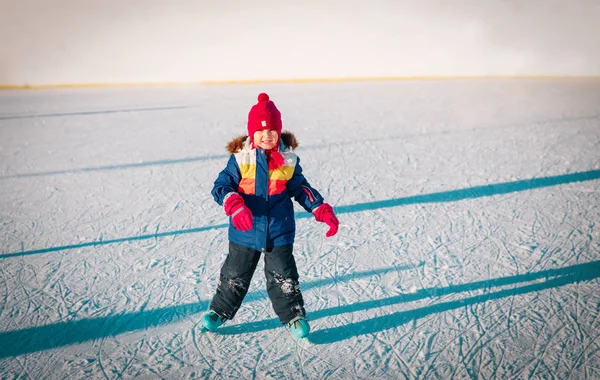 Heureuse petite fille apprendre à patiner en hiver — Photo